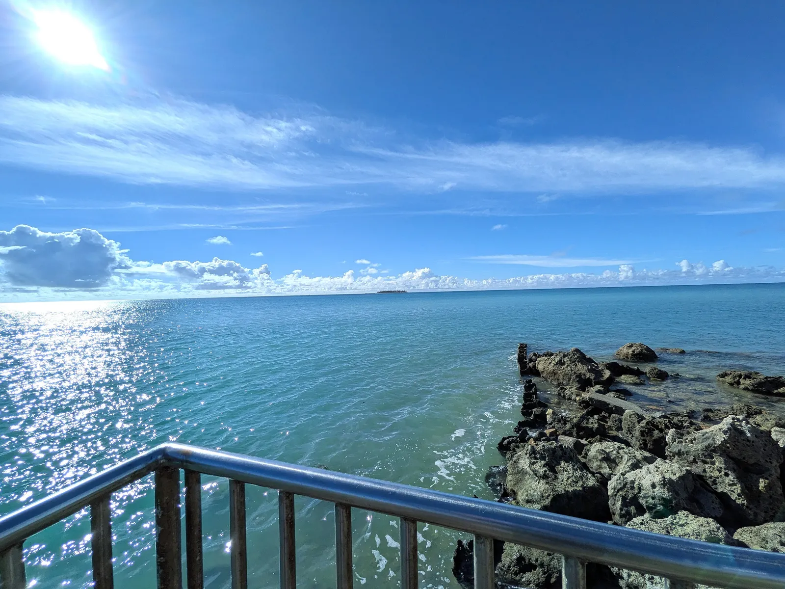 The rocky end of the breakwater at Smiling Cove Marina, where the seawall path meets the reef rock