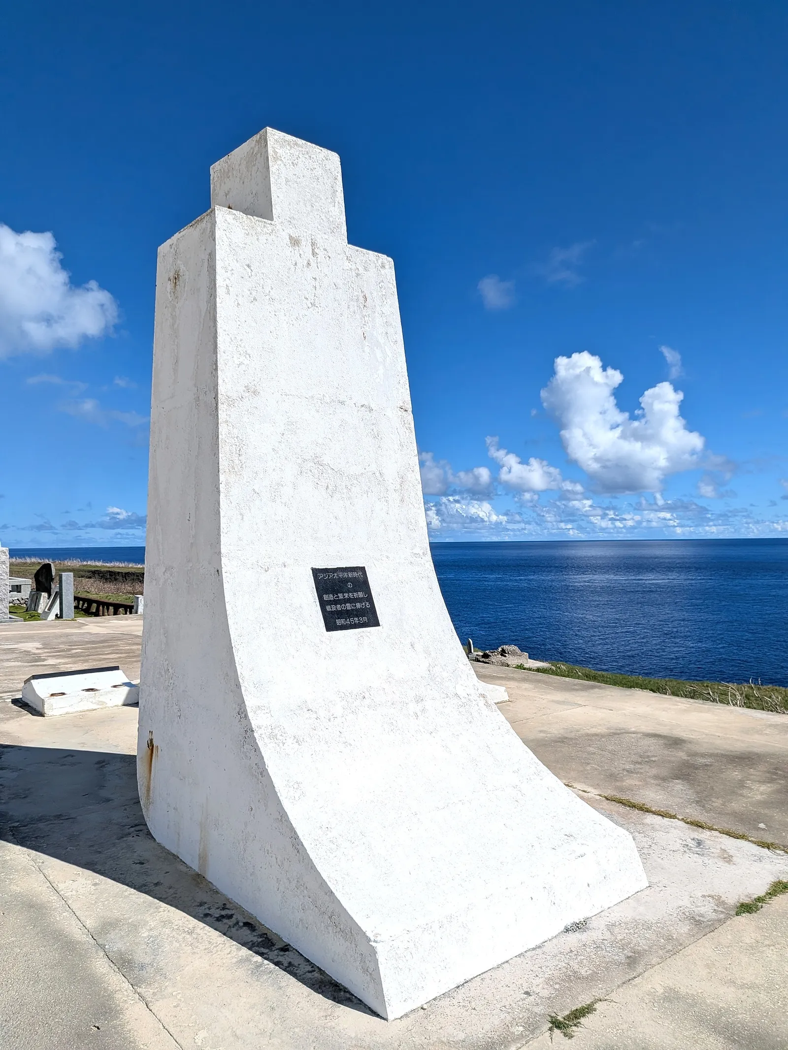 One curved white pylon of the Tower of the Pacific at Banzai Cliff, seen against the open sea